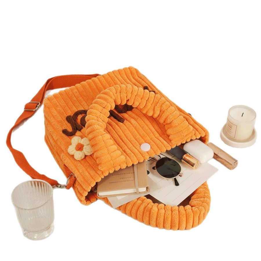 Inside a real purse, holding a notebook, sunglasses and small essentials
